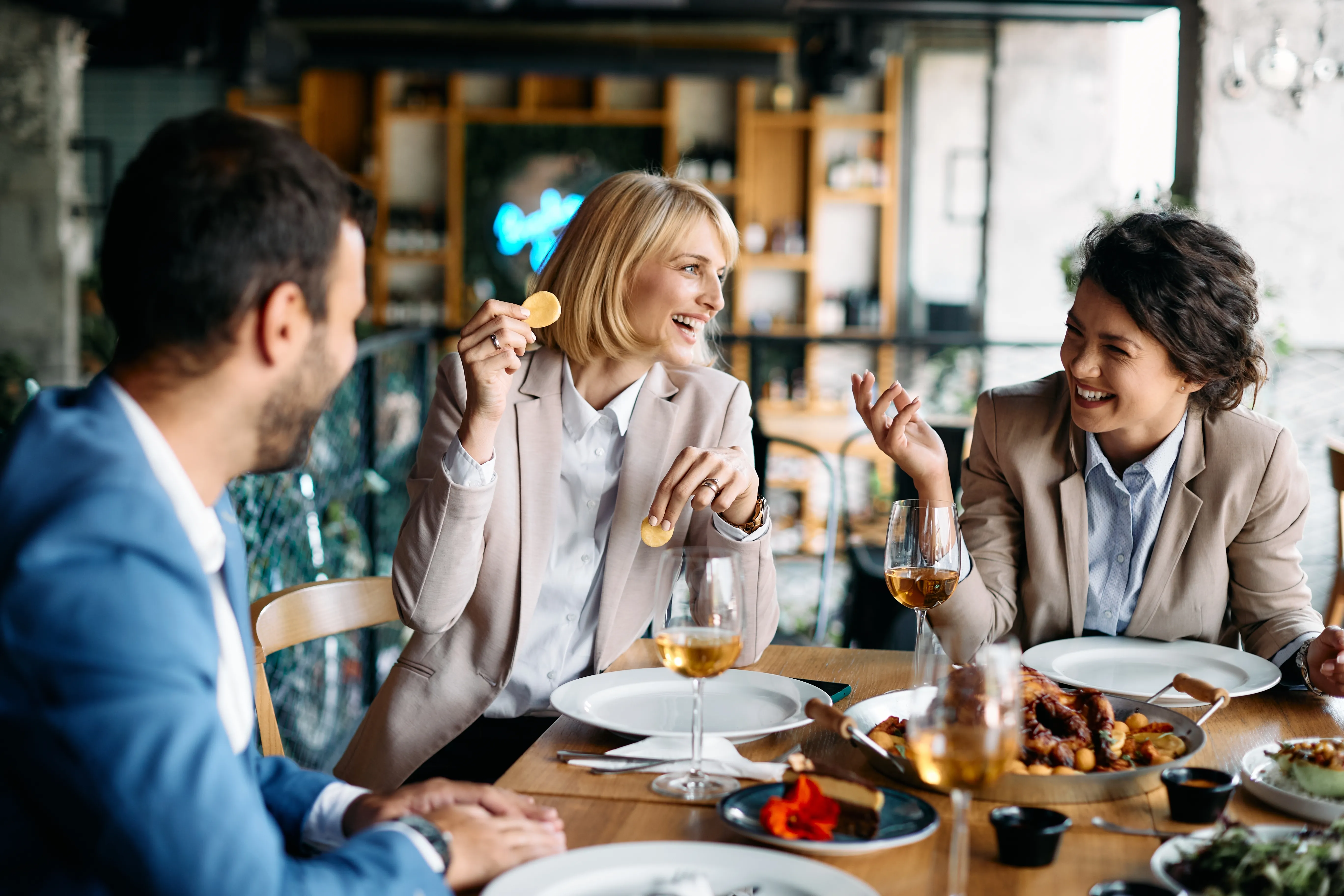 Collegues d'affaires riant lors d'un diner au restaurant