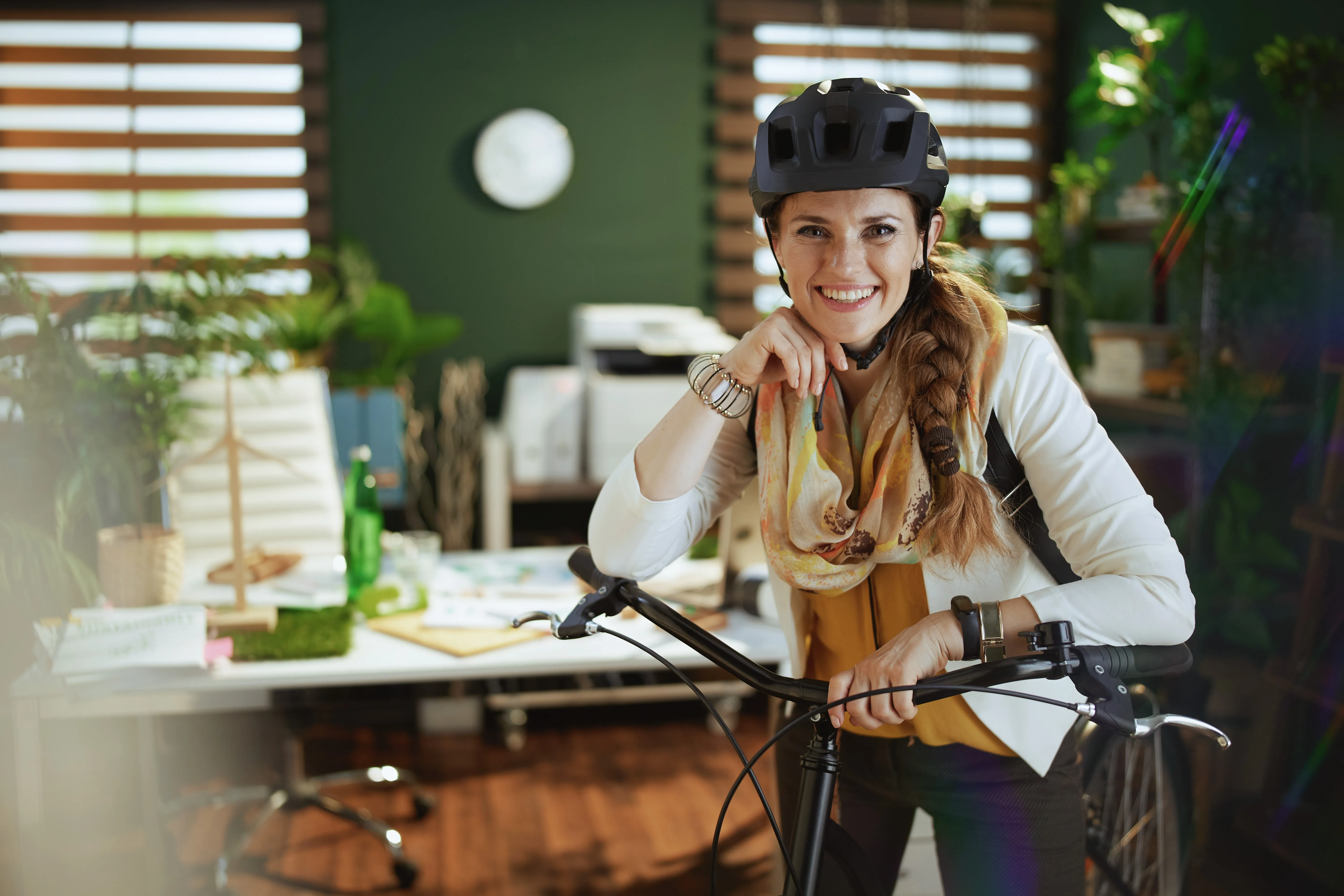 Glimlachende vrouw met fiets op kantoor -- ecologische mobiliteit