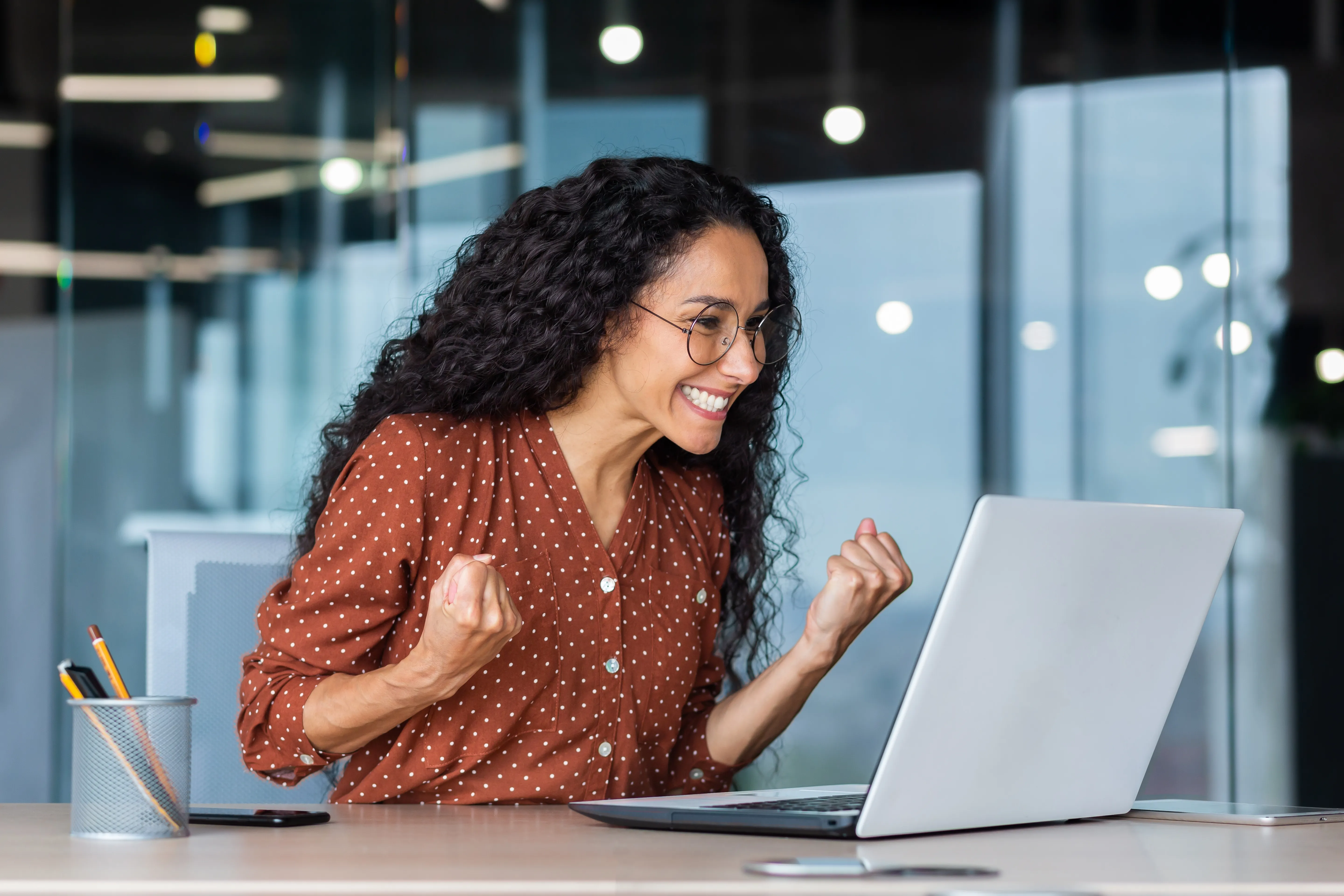 Happy woman at the office celebrating good news